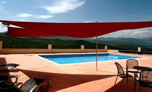 una piscina con una sombrilla roja en el patio en Lo Boix: Le Canigou, en Saint-Laurent-de-Cerdans