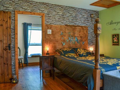 um quarto com uma cama e uma parede de tijolos em The Resting Dragon em Ystalyfera