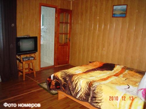 a bedroom with a bed and a tv in it at Asfandiar Hotel in Karakol