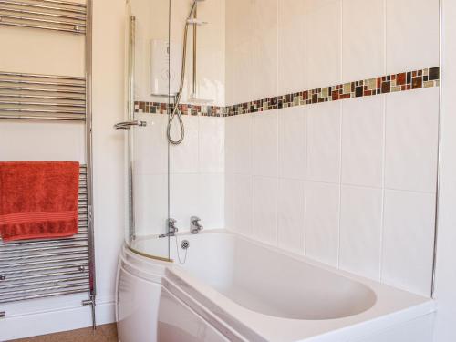een witte badkamer met een bad en een douche bij Fell Mount in Grange Over Sands