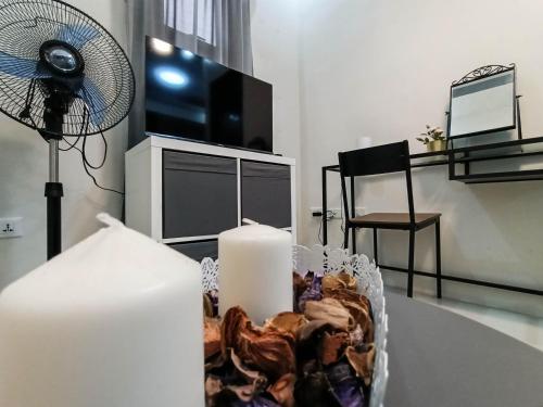 a living room with a table with a candle and a fan at Manzil Anilao B&B in Mabini