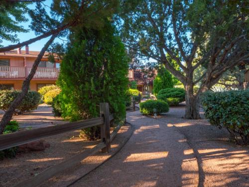 a wooden fence in a park with trees and bushes at Sky Ranch Lodge in Sedona
