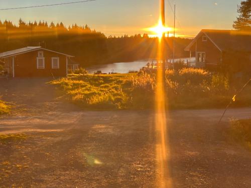 a sunset over a field with a house and a road at Luxus Tiny House Saagala in Tornio