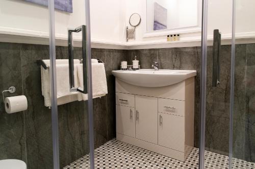 a bathroom with a white sink and a shower at Kylemore House boutique apartments - Fishermans Perch in Kylemore