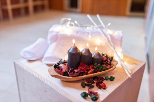 a plate of food on a table with candles at Hotel Enzo Moro in Sùtrio