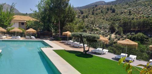 a swimming pool with chairs and a view of a mountain at Cortijo el Cercadillo in Bedmar