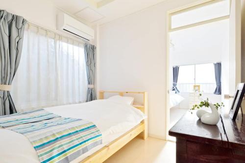 a bedroom with a bed and a desk and a mirror at Third&Place Namba_Ashiharabashi/芦原橋 in Osaka