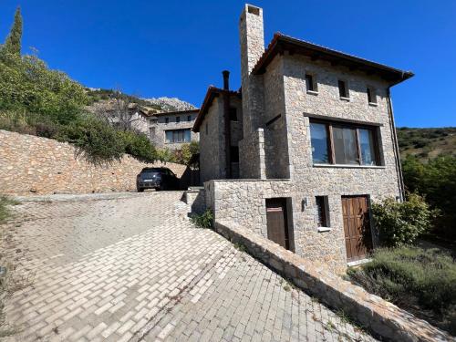 a stone house on a cobblestone street at Plethora Arachova Luxury Chalet in Arachova