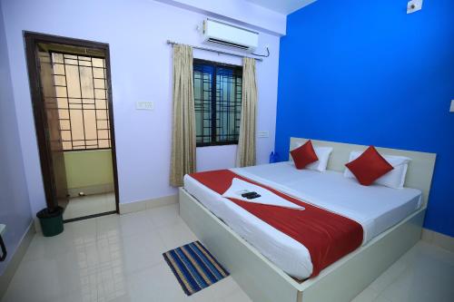 um quarto com uma cama grande e almofadas vermelhas em Railview inn Bhubaneswar em Bhubaneshwar
