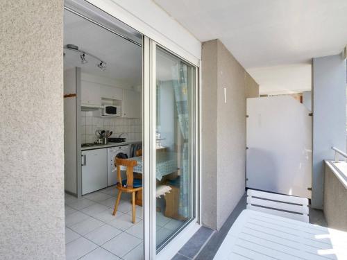 - une cuisine avec une porte coulissante en verre et un réfrigérateur dans l'établissement Studio cabine cosy pour 4 pers. avec balcon au sud et parking, à deux pas du centre de Luz-Saint-Sauveur - FR-1-402-59, à Luz-Saint-Sauveur