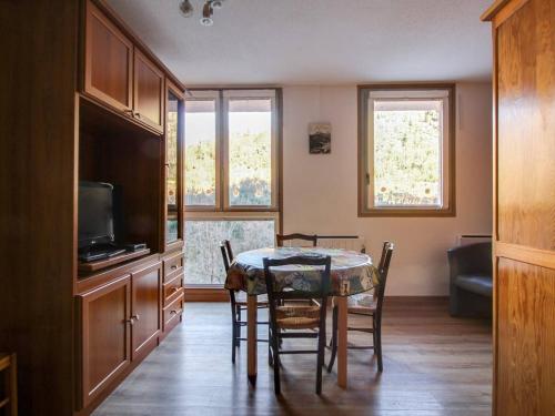 une salle à manger avec une table, des chaises et une télévision dans l'établissement Studio accueillant 4 pers., proche thermes, Luz-Saint-Sauveur - FR-1-402-74, à Luz-Saint-Sauveur