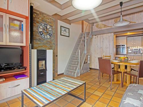 Il comprend un salon avec un escalier, une table et une cuisine. dans l'établissement Chalet cosy avec garage et vues, 3 niveaux, 6 pers, proche Luz, animaux admis - FR-1-402-54, à Viella