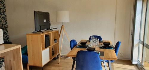 een eetkamer met een tafel en blauwe stoelen bij Escapade marine a carnac Maison 4 personnes toute équipée, au calme entre plage et ville in Carnac