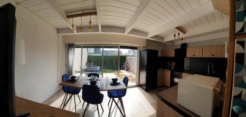 een keuken met een tafel en stoelen in een kamer bij Escapade marine a carnac Maison 4 personnes toute équipée, au calme entre plage et ville in Carnac