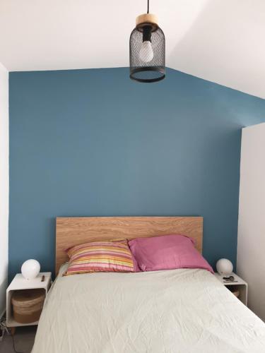- une chambre avec un mur bleu et un lit dans l'établissement Adorable Romantique Maison d'hôte, piscine, wifi 4G, proche BEZIERS, à Cers