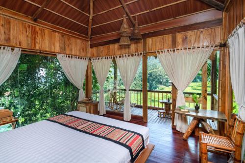 - une chambre avec un lit dans une pièce dotée de fenêtres dans l'établissement Puluong Luna Resort, à Pu Luong