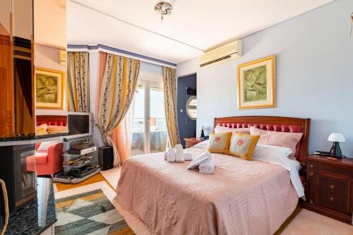 een slaapkamer met een groot bed en een televisie bij Villa Serenity a luxury 7 bed villa at Kymi Evia in Paralia Kimis