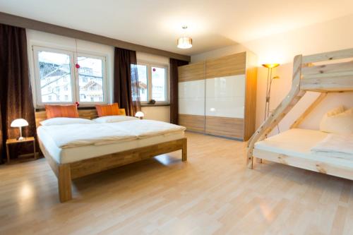 a bedroom with two bunk beds and a ladder at Ski-n-Lake City Apartments in Zell am See