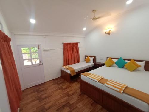 a bedroom with two beds and a window at Anthy’s Guesthouse and Restaurant in Benaulim