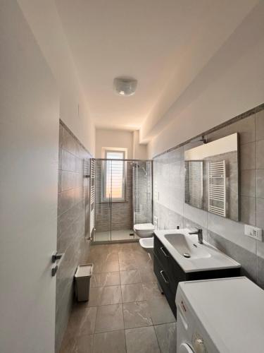 ein Badezimmer mit 2 Waschbecken, einer Dusche und 2 WCs in der Unterkunft La Piazzetta in Olivarella