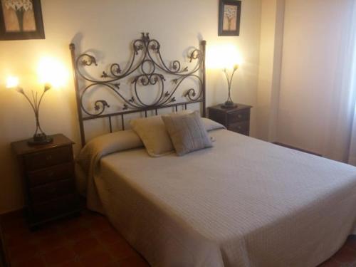 a bedroom with a large white bed with two night stands at Rural Vega de Cazalla in Cazalla de la Sierra