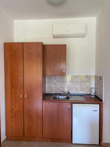 a kitchen with wooden cabinets and a sink at Guesthouse Anestis in Angistron