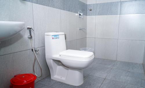 Łazienka z białą toaletą i umywalką w obiekcie Atmos Inn w mieście Kozhikode