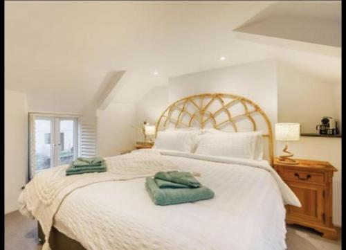 a bedroom with a large white bed with two towels on it at Charming 2-Bed Cottage in Wadebridge Cornwall in Wadebridge