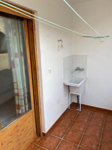 a bathroom with a sink in the corner of a room at Casa Rural Cerezo in Torviscón