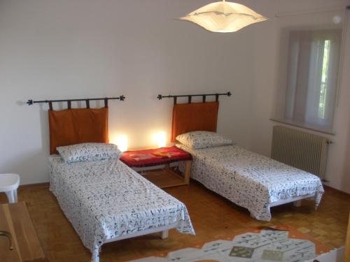 a room with two beds and a table in it at B&B Castellani in Fanna