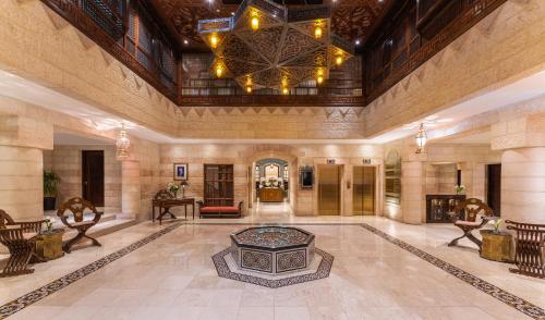 a large lobby with a fireplace and a chandelier at Mövenpick Resort Petra in Wadi Musa