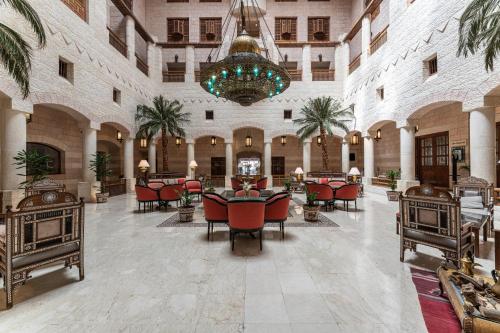 a large lobby with tables and chairs and a chandelier at Mövenpick Resort Petra in Wadi Musa