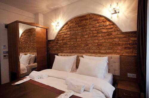a bedroom with two beds and a brick wall at Pera Line Hotel in Istanbul
