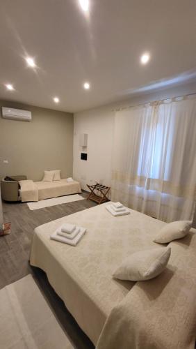 - une chambre avec 2 lits et des serviettes dans l'établissement A Su Mulinu - Locazione turistica, à Pozzomaggiore