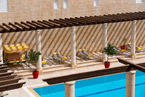 a patio with chairs and a swimming pool at Mövenpick Resort Petra in Wadi Musa