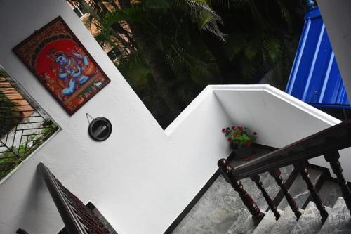 a staircase with a white wall with a plant on it at Sky Palace Beach Hotel in Trivandrum