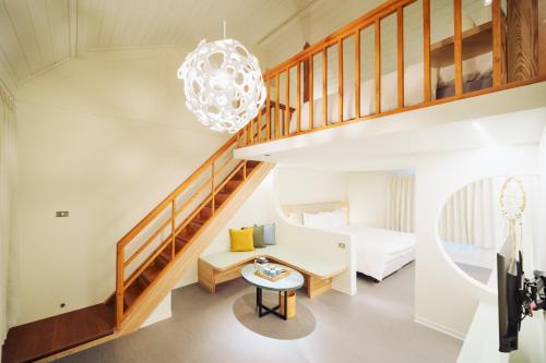 FenglinにあるChu Resort Hualienの階段、ベッド、テーブルが備わる客室です。