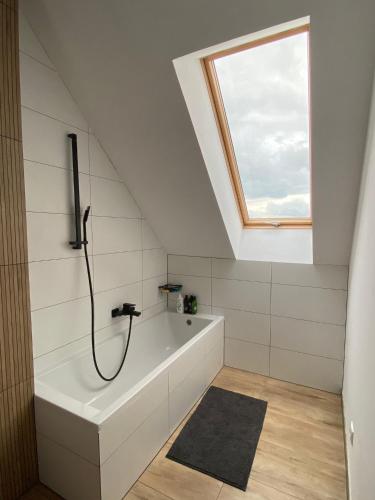 a bathroom with a bath tub and a window at Domki przy Ogrodach in Goczałkowice-Zdrój