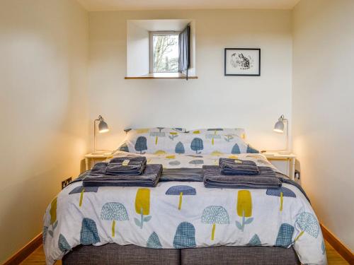 a bedroom with a bed with a blue and yellow comforter at The Old Mill in Fettercairn
