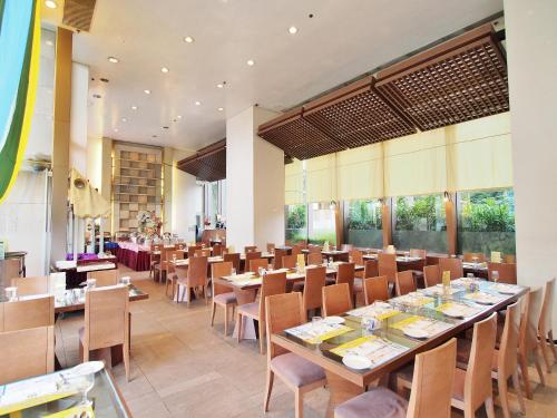 a restaurant with wooden tables and chairs and windows at Winland 800 Hotel - Formerly Mexan Harbour Hotel in Hong Kong