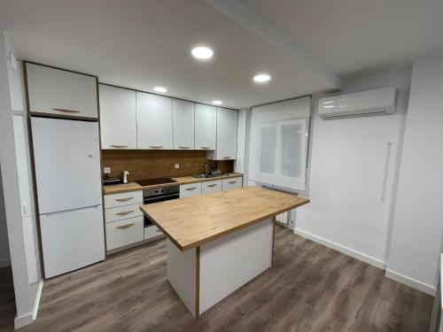 a kitchen with white cabinets and a wooden counter top at Piso centro de valdemoro in Valdemoro