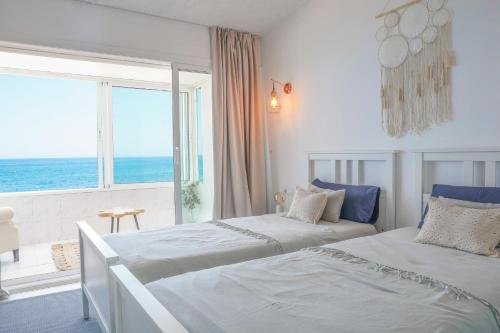2 Betten in einem Zimmer mit Meerblick in der Unterkunft Beach Villa Dorada in Estepona