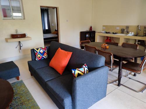 a living room with a blue couch and a table at Vee's Villa in Kilifi