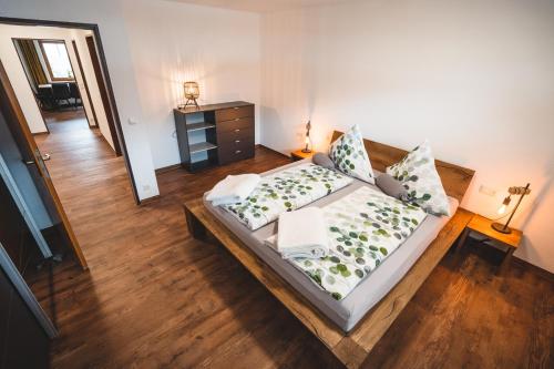 una camera con letto e pavimento in legno di Ferienwohnung Murmeleblick a Oberstdorf