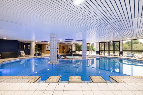 a large swimming pool in a large building at Mercure Tours Sud in Joué-lès-Tours