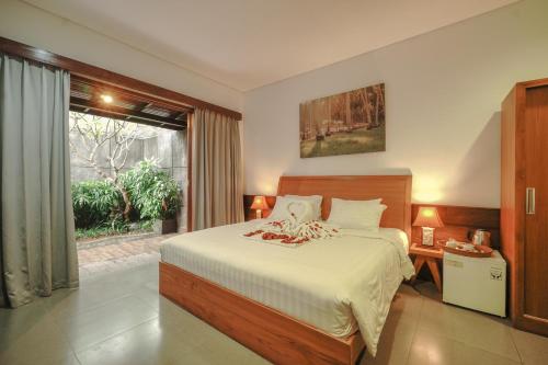 a bedroom with a large bed and a window at Rama Village in Canggu