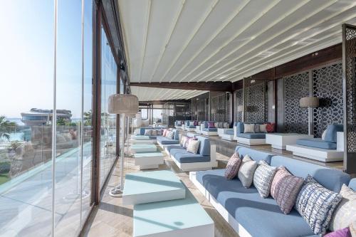 a lobby with blue and white couches and windows at Four Seasons Hotel Doha in Doha