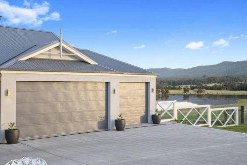 a house with a garage door on a driveway at Soulful Grande Manor with Mineral Pool in Millfield
