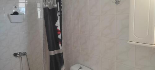 a bathroom with a shower with a black and white shower curtain at cottage in vellies-nice place for families in Pappadhiánika