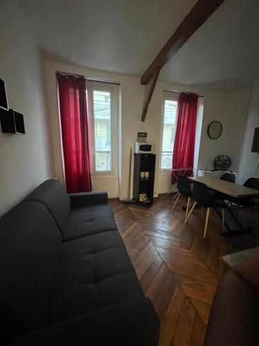a living room with a couch and a table at Appartement au centre de Vincennes in Vincennes